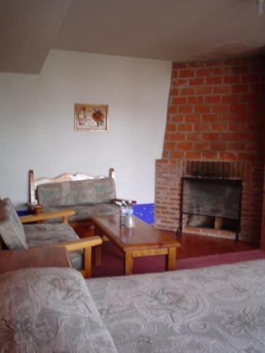 a living room with a brick fireplace and a bed at Hotel Bella Vista in Huasca de Ocampo