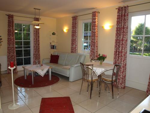 a living room with a couch and a table and chairs at Ferienwohnung Fischerkoje in Wustrow