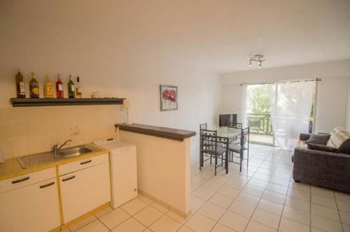 a kitchen and living room with a couch and a table at L'embarcadère in Mimizan-Plage