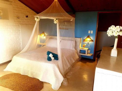 サン・ミゲル・ド・ゴストーゾにあるPousada Vila Bacanaのベッドルーム(天蓋付き白いベッド1台付)