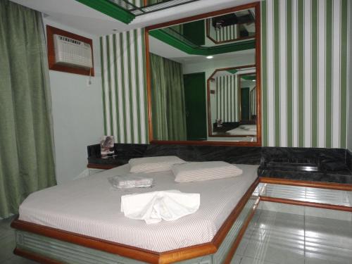 a bed in a room with a large mirror at Hotel Premier (Adult Only) in Nilópolis