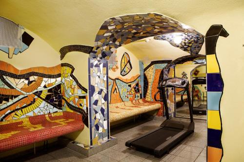 una habitación con un gimnasio con cinta de correr y una habitación con pinturas en Grand Hotel Downtown, en Frankfurt