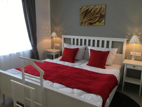 1 dormitorio con 1 cama grande con almohadas rojas en Wolffs-Idyll, en Prerow