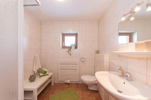 ein weißes Bad mit einem Waschbecken und einem WC in der Unterkunft Bio-Bauernhof Niederlehen in Fieberbrunn