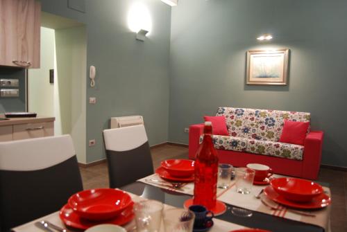 a living room with a table and a red couch at Relais Monti Apartments in Vallo della Lucania