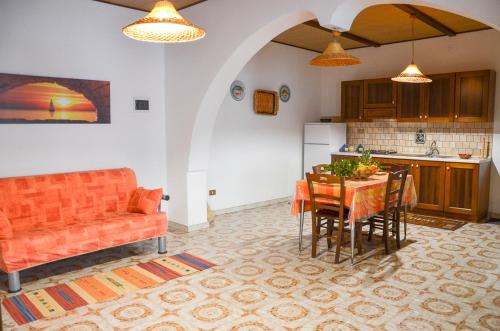 カステッルッツォにあるLa Grande Palmaのキッチン(オレンジ色のソファ、テーブル、椅子付)