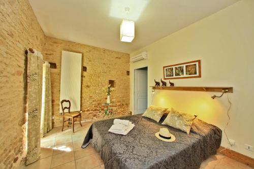 une chambre avec un lit avec un chapeau dessus dans l'établissement Gîtes de charme Le Cheyssignaguet, à La Chapelle-Aubareil