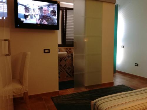 a room with a tv on the wall and a bed at villa peppino in Montallegro