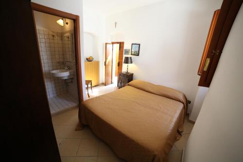 a bedroom with a bed and a bathroom with a sink at Case Vacanza Al Borgo Antico in Vico del Gargano