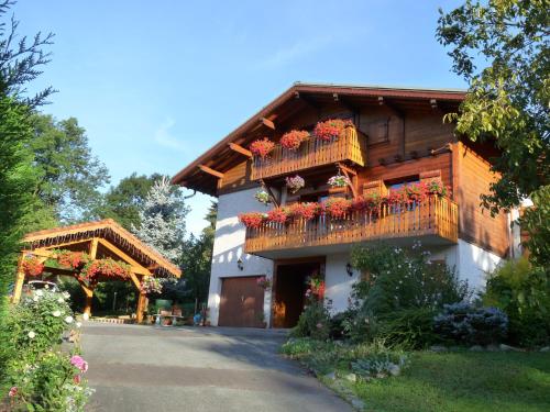 un bâtiment avec des boîtes de fleurs sur son côté dans l'établissement Chalet coup de coeur, à Passy