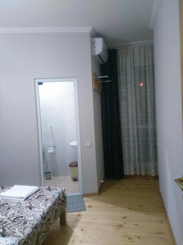a bedroom with a mirror and a bed in a room at guest house katia tbilisi in Tbilisi City