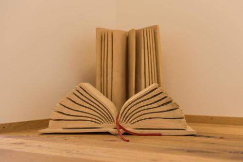 an open book on a table next to two books at Berghotel Chäserstatt in Ernen