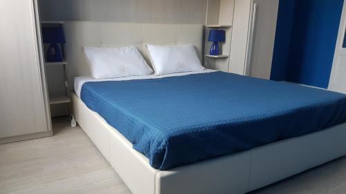 een groot bed met een blauwe deken en witte kussens bij JustBlue - Città Studi/Piola/Lambrate in Milaan