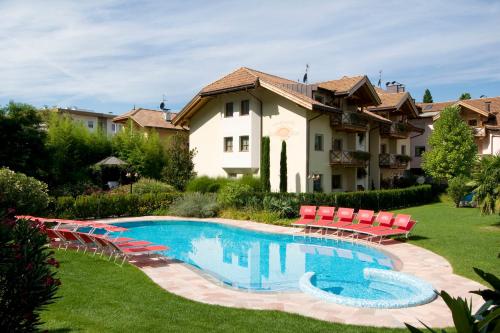 a patio area with chairs, a pool, and a pool table at Business Resort Parkhotel Werth in Bolzano