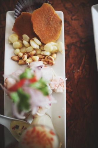 a white plate with food on a table at Bamboo Lodge Paracas in Paracas
