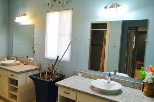 Casa Brisa Gran Pacífica Resort في San Diego: حمام به مغسلتين ومرآة كبيرة