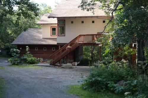 ein Haus mit einer Terrasse und einem Hund, der davor steht in der Unterkunft Eagle Peak Guesthouse in Eagle River