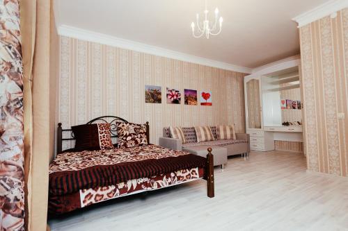 クラスノダールにあるKvartira na sutkiのベッドルーム(ベッド1台、ソファ付)