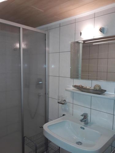 a white bathroom with a shower and a sink at Ferienhaus Nadine in Kappl