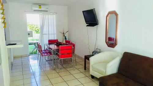 a living room with a couch and a table and a mirror at Casa Flores in Acapulco