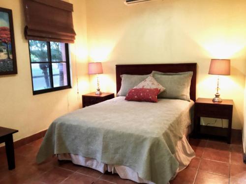 a bedroom with a bed with two lamps on two tables at Casa Carolina Gran Pacífica Resort in San Diego