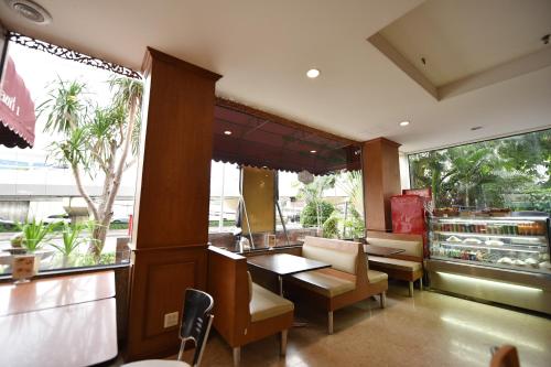 een restaurant met een tafel en stoelen en een raam bij Bangkok City Suite in Bangkok