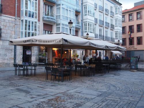 a patio with tables and chairs and umbrellas at Minaya in Burgos