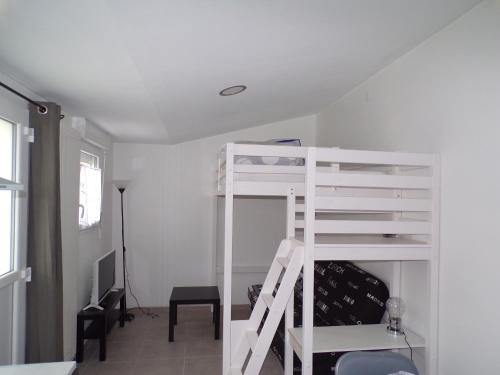 Cette chambre comprend un lit superposé blanc et une chaise. dans l'établissement Studio Violine, à Berck-sur-Mer