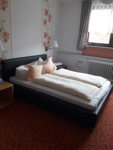 Schlafzimmer mit einem Bett mit weißer Bettwäsche und Kissen in der Unterkunft Haus Helene in Einruhr