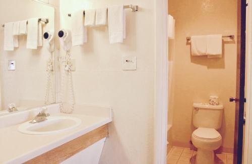 a white bathroom with a sink and a toilet at River Inn in Susanville