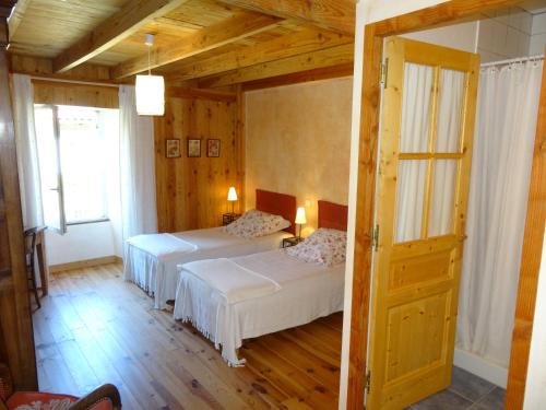- 2 lits dans une chambre dotée de murs en bois et de parquet dans l'établissement Le hameau de Robert, à Boucieu-Le-Roi