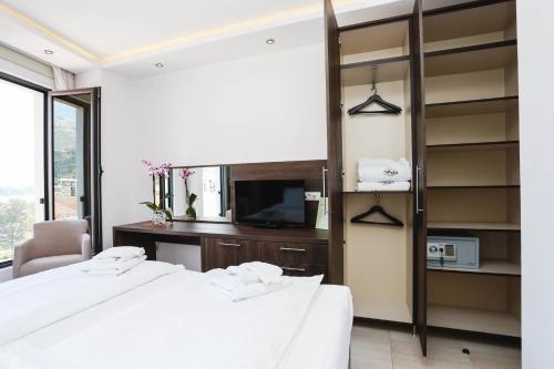 a bedroom with two beds and a desk and a tv at Arka Rooms&Apartments in Budva