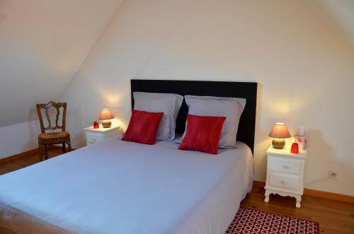 ein Schlafzimmer mit einem großen weißen Bett mit roten Kissen in der Unterkunft Domaine de la Ronville in Wimereux