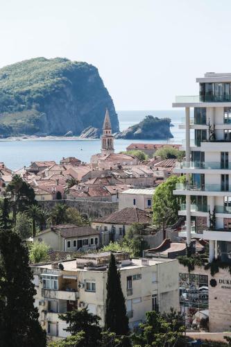 a city with buildings and a church and the water at Arka Rooms&Apartments in Budva