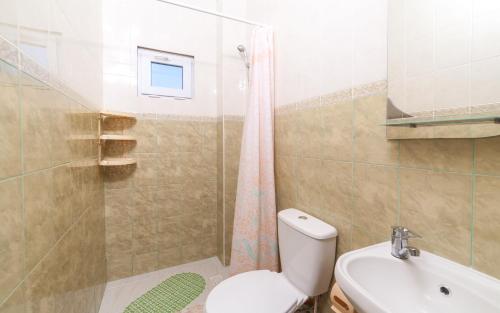 a bathroom with a toilet and a shower and a sink at Мини Отель Милый in Sanzhiyka