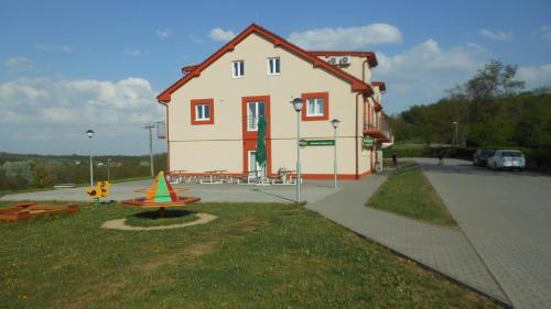 une petite maison avec une aire de jeux en face de celle-ci dans l'établissement Mobilheim Výr, à Výrovice