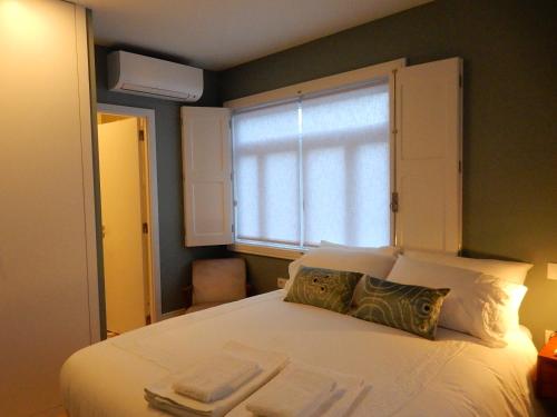 ポルトにあるPorto Traveler Apartmentのベッドルーム(大きな白いベッド1台、窓付)