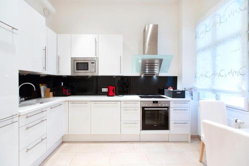 una cocina blanca con armarios blancos y electrodomésticos blancos en Anna Maria Apartments in Vienna Citycenter, en Viena