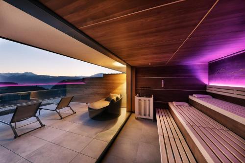 a balcony of a house with a table and benches at Hotel Avelina in Avelengo