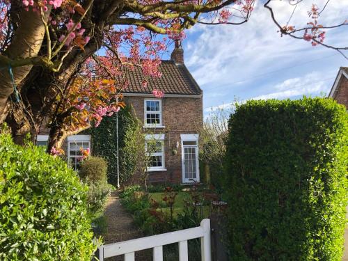 a brick house with a white fence in front of it at Ceilidh Cottage in York