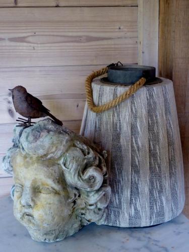 a bird sitting on a statue of a head at De Epicurist in Hasselt