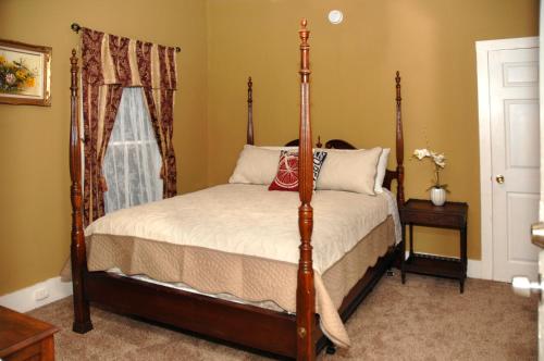 a bedroom with a four poster bed and a window at Historic Luxury Two Bedroom Apartment in St. Augustine