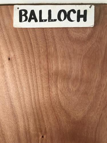 a sign on a wooden wall with the word ballogi at Drifters@One Mile in Negril