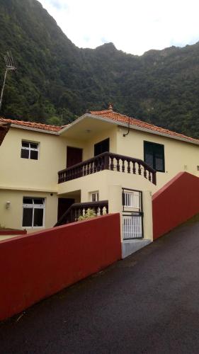 une maison avec une clôture rouge en face d'une montagne dans l'établissement Casa Reis, à Santana