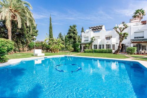 a large blue swimming pool in front of a house at Mini Motel at Los NaranjosGC in Marbella