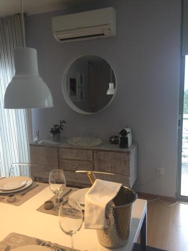 a table with two wine glasses and a mirror at Casa dos Loureiros in Ponte de Lima