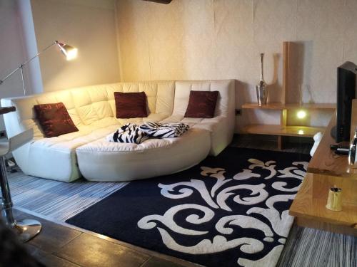 a living room with a white couch and a rug at A Bolota in Évora