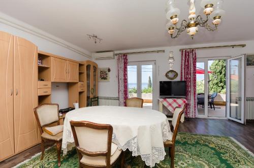 a dining room with a table and chairs at Apartments and Room Luka in Klenovica