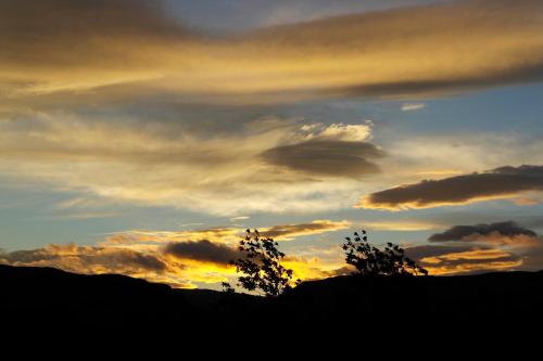 a sunset with two trees and a cloudy sky at Hagi 2 Road 62 nr 1 in Hagi