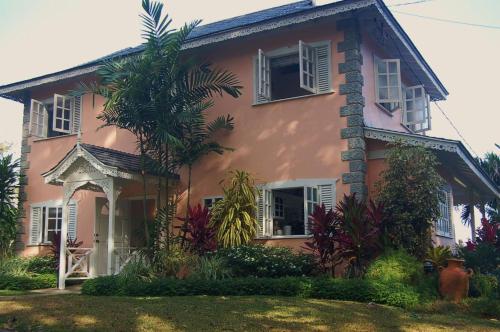 a pink house with a palm tree in front of it at Plantation Beach Villas in Black Rock